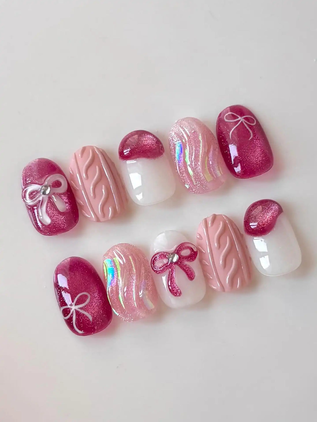 Handmade pink press-on nails with shimmer, bow, ribbon, and knit texture designs