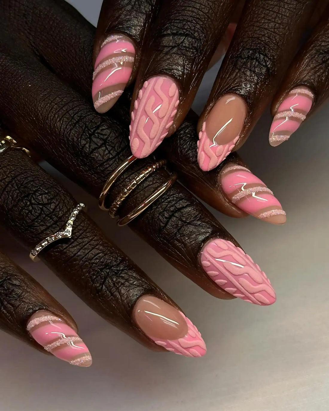 Handmade pink press-on nails with textured sweater pattern and glitter stripe accents