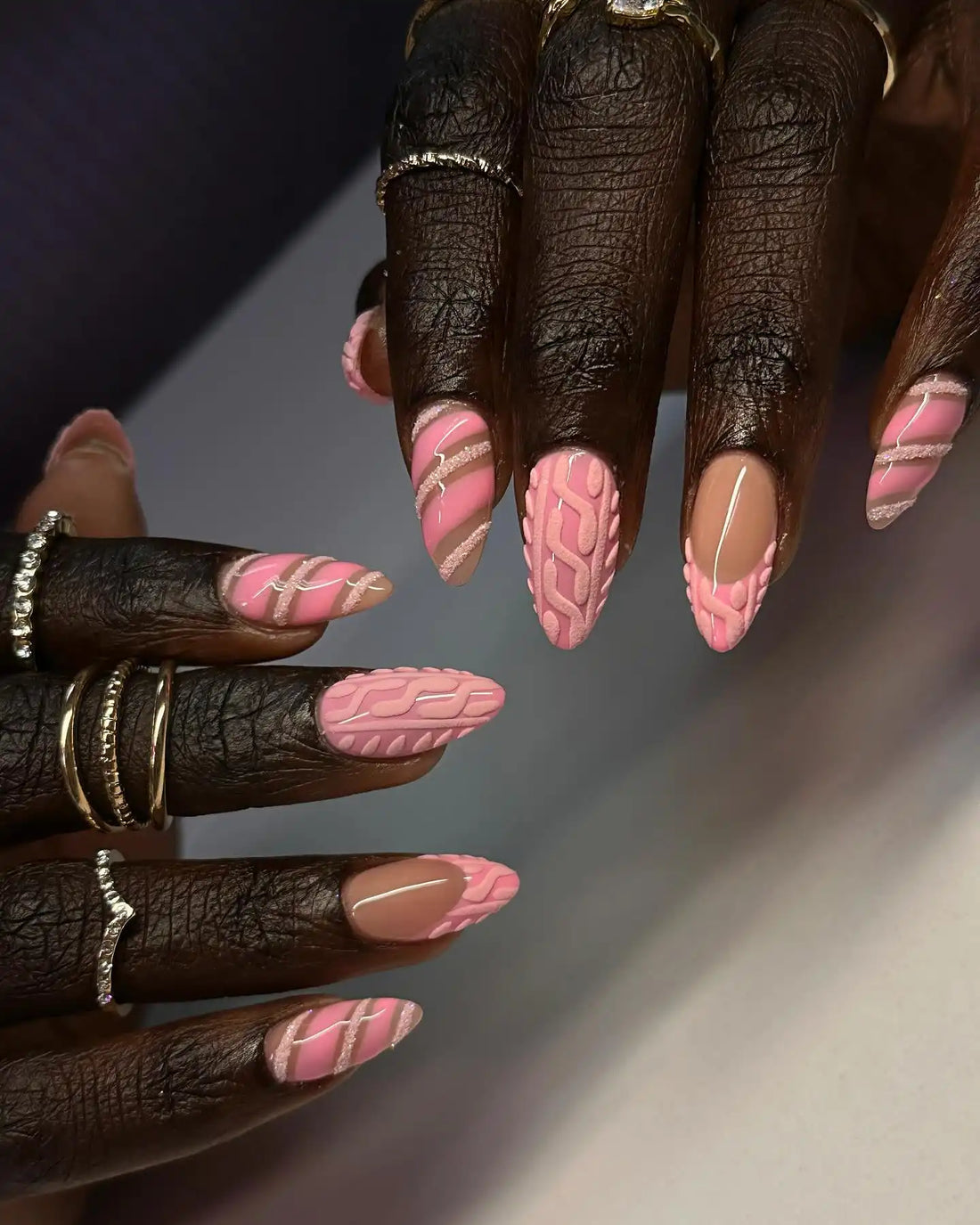 Handmade pink press-on nails with textured sweater pattern and glitter stripe accents