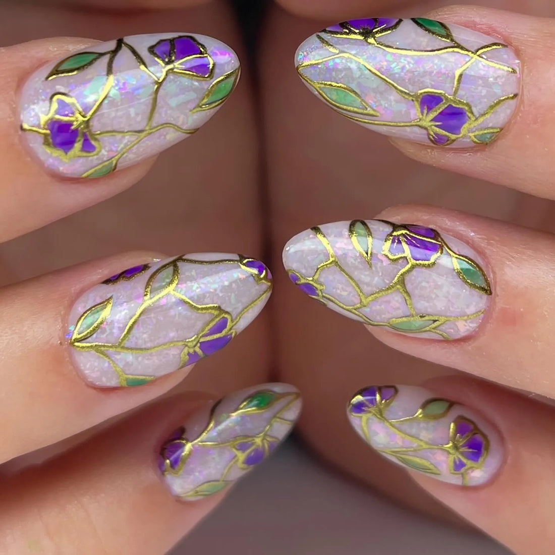 Handmade press-on nails with purple floral stained glass design and gold foil accents