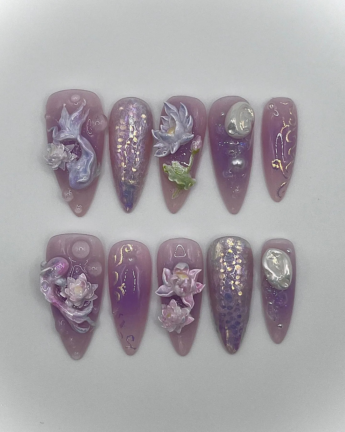 Handmade iridescent purple press-on nails with 3D lotus flowers, mermaid and fantasy designs.