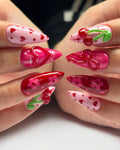 Handmade press-on nails with pink, red cherry, heart, floral, and 3D bow designs.