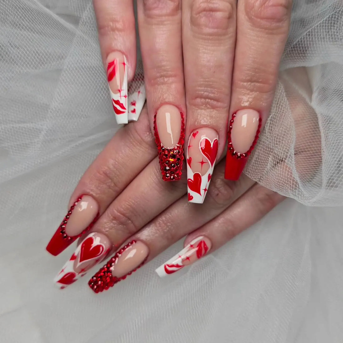 Handmade red French tip press-on nails with heart and crystal designs for Valentine's Day