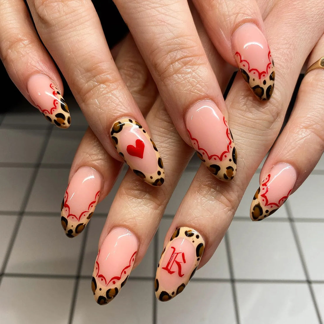 Handmade press-on nails with red heart, leopard print, lace French tips and letter accent design.