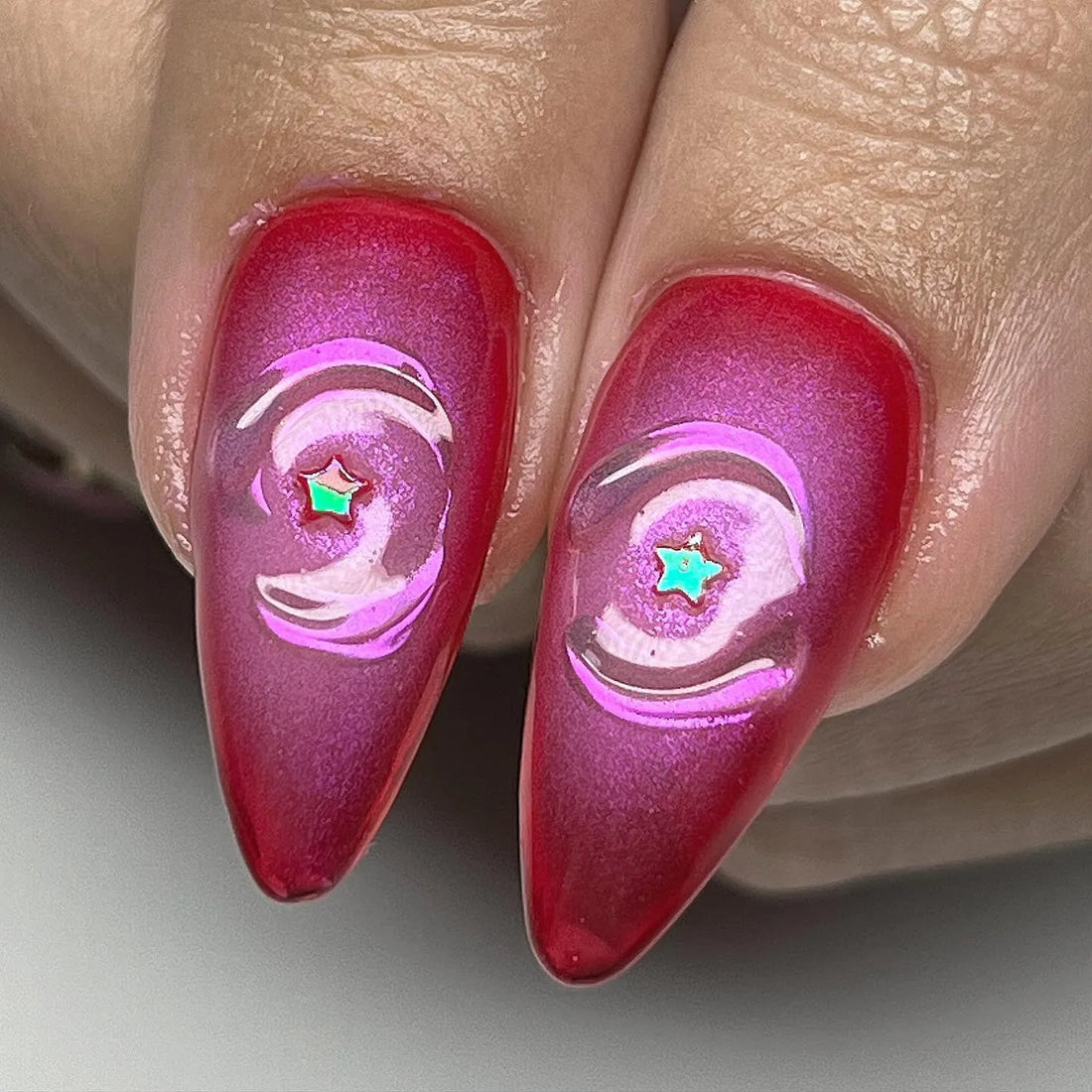Handmade long press-on nails with red tips, pearls, hearts, stars, and clear festive accents.