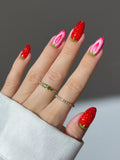 Hand with handmade strawberry fruit design summer press-on nails, red and pink kawaii style.