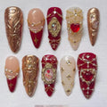 Handmade red and gold press-on nails with pearls, gems, and baroque embellished designs