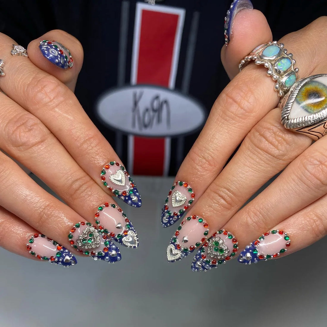 Handmade royal blue ombre heart press-on nails with colorful chrome gemstones.