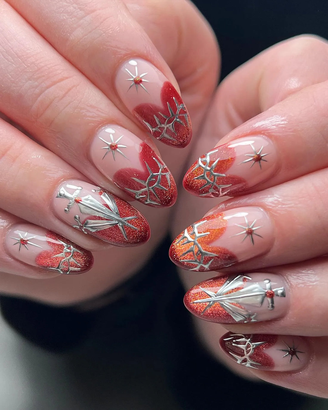 Handmade almond press-on nails with red glitter, silver sword, thorn, and star designs