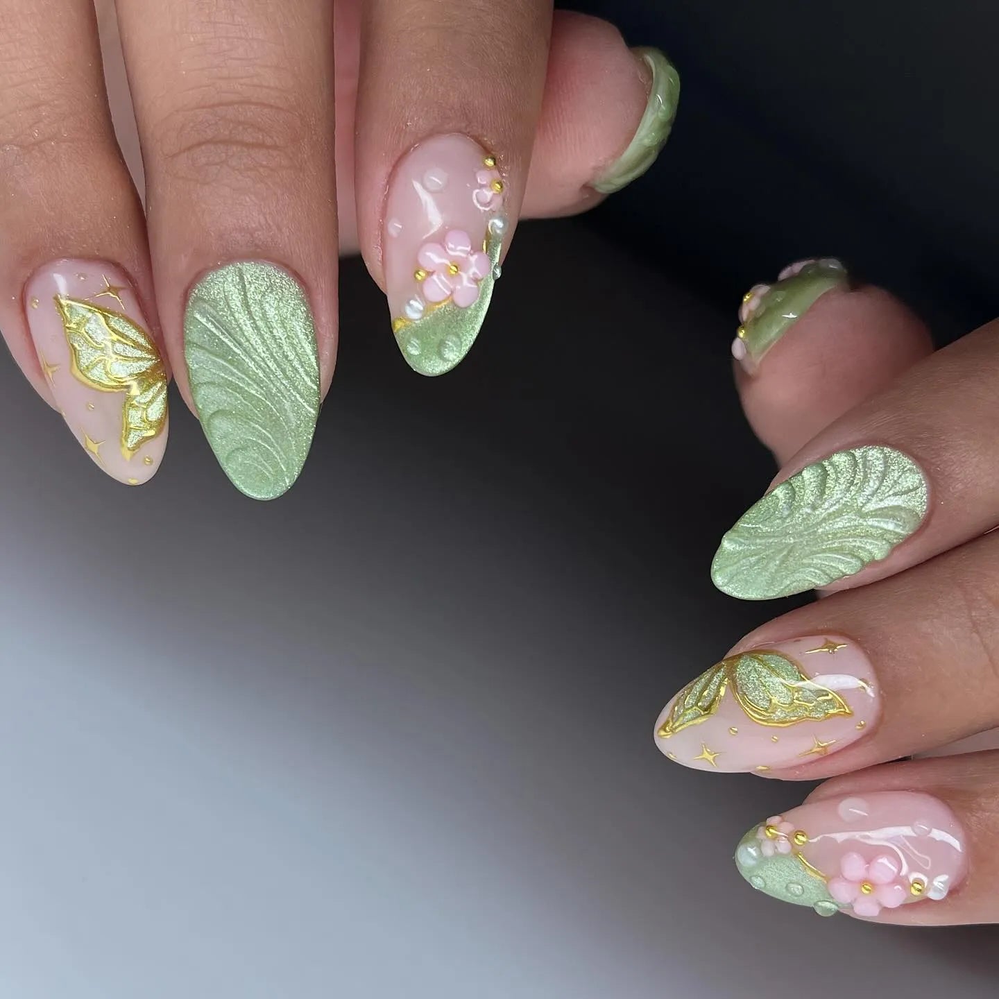 Handmade sage green press-on nails with butterfly, floral, and leaf designs