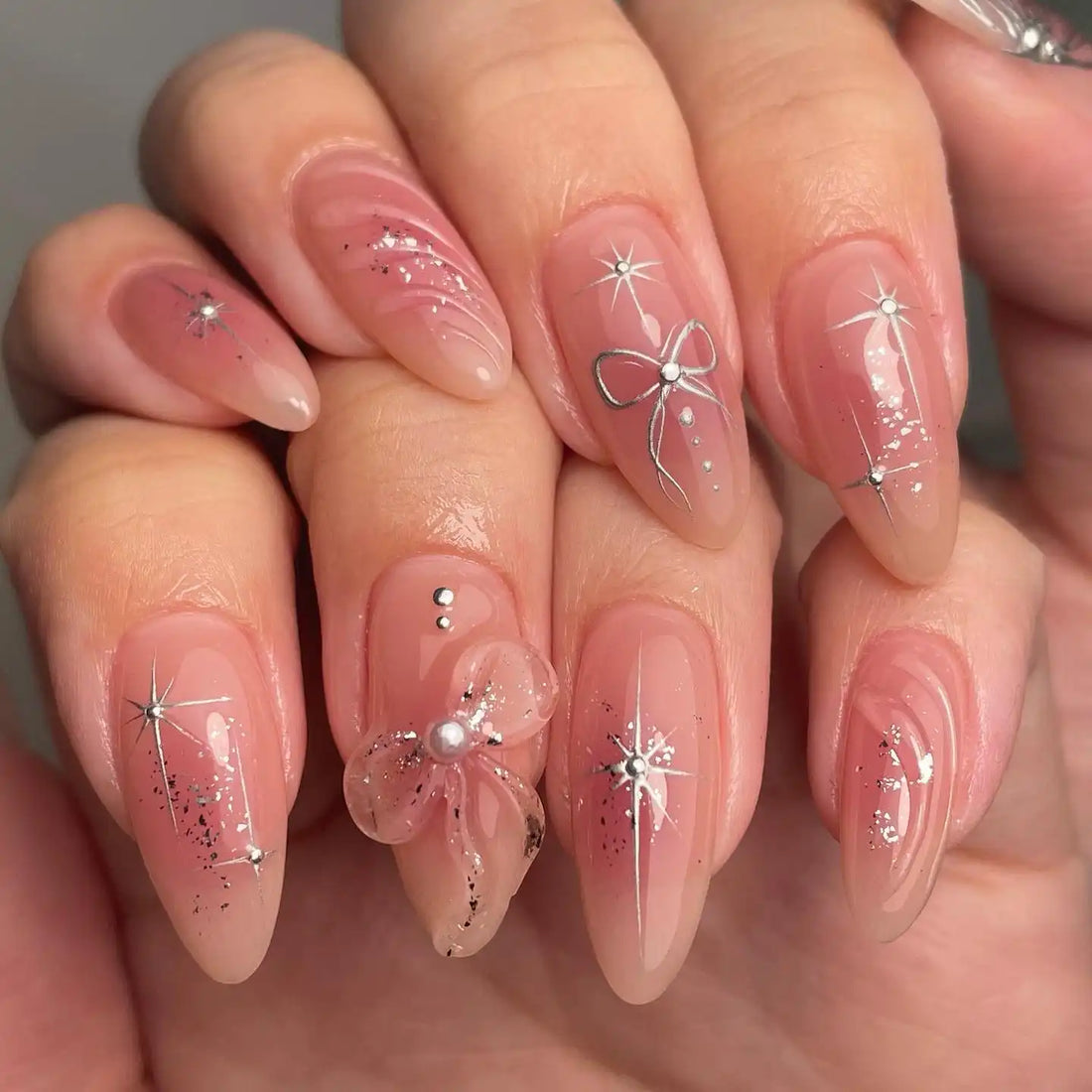 Handmade pink press-on nails with silver star, butterfly, and 3D bow designs