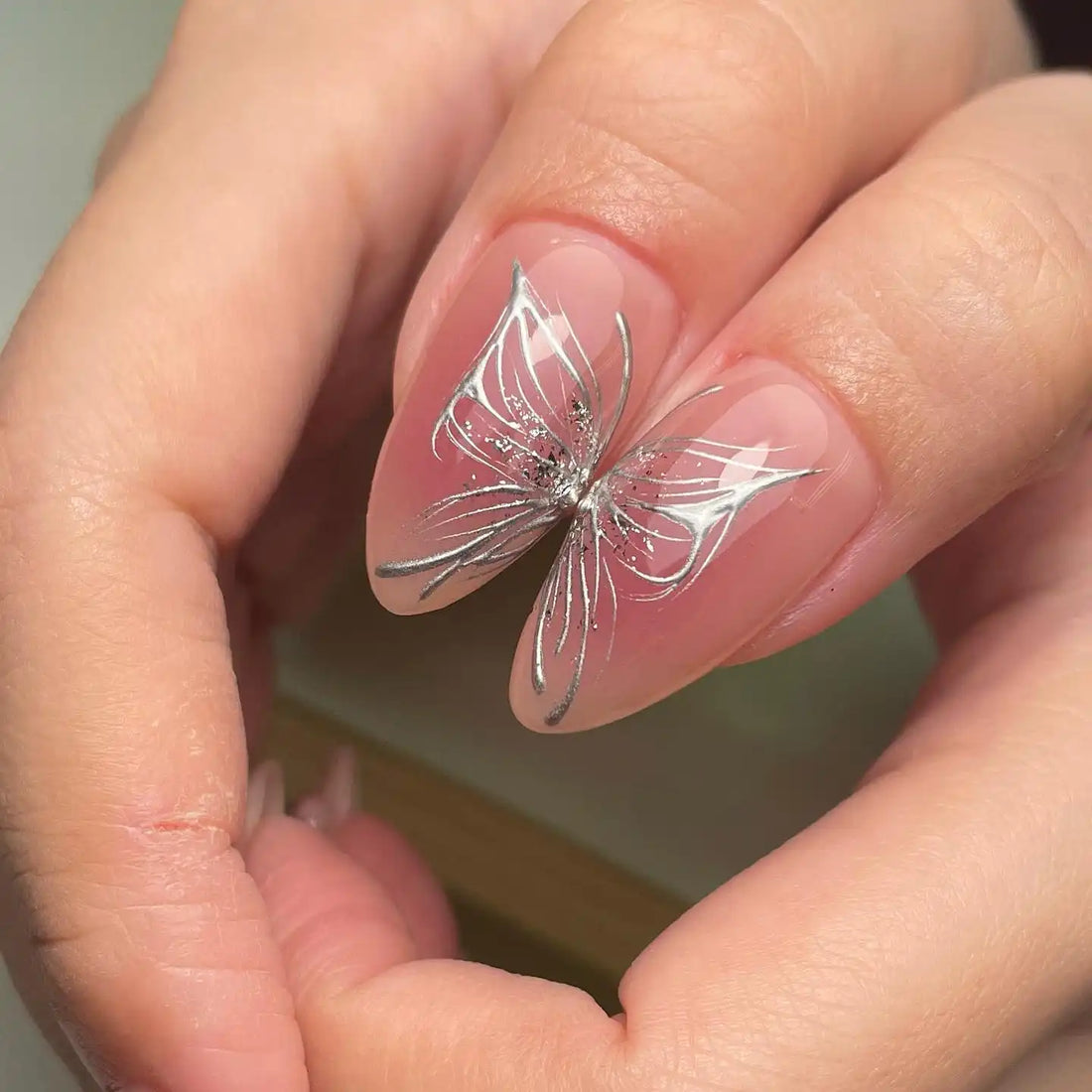 Handmade pink press-on nails with silver star, butterfly, and 3D bow designs