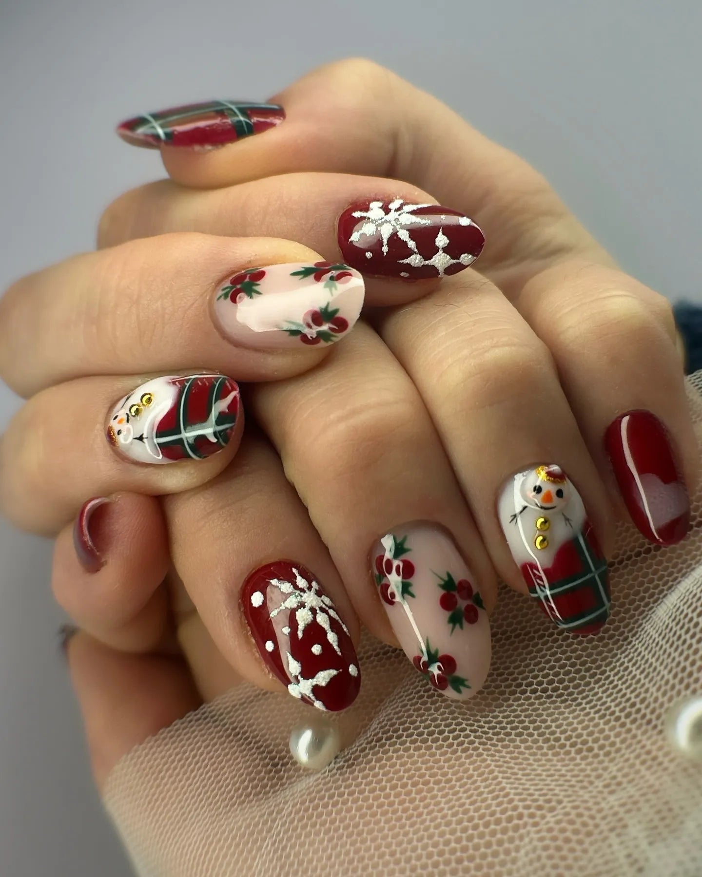Handmade press-on nails with snowman, holly, red green plaid, and winter Christmas designs.