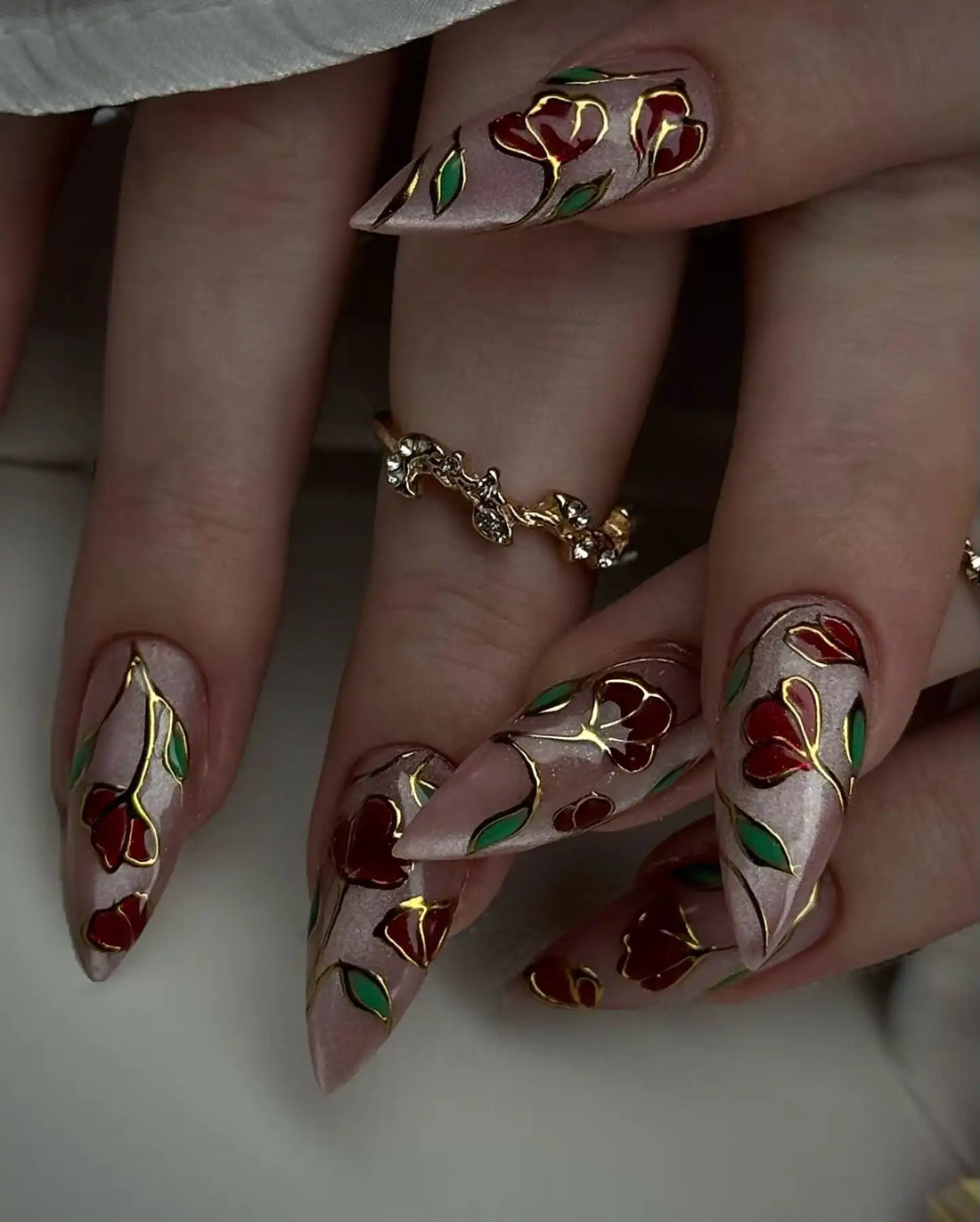 Handmade press-on nails with stained glass rose gold floral design and long stiletto shape.