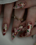 Handmade rose gold press-on nails with red and green floral stained glass design