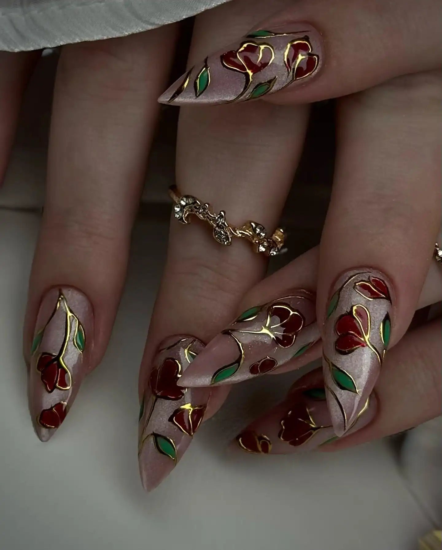 Handmade rose gold press-on nails with red and green floral stained glass design