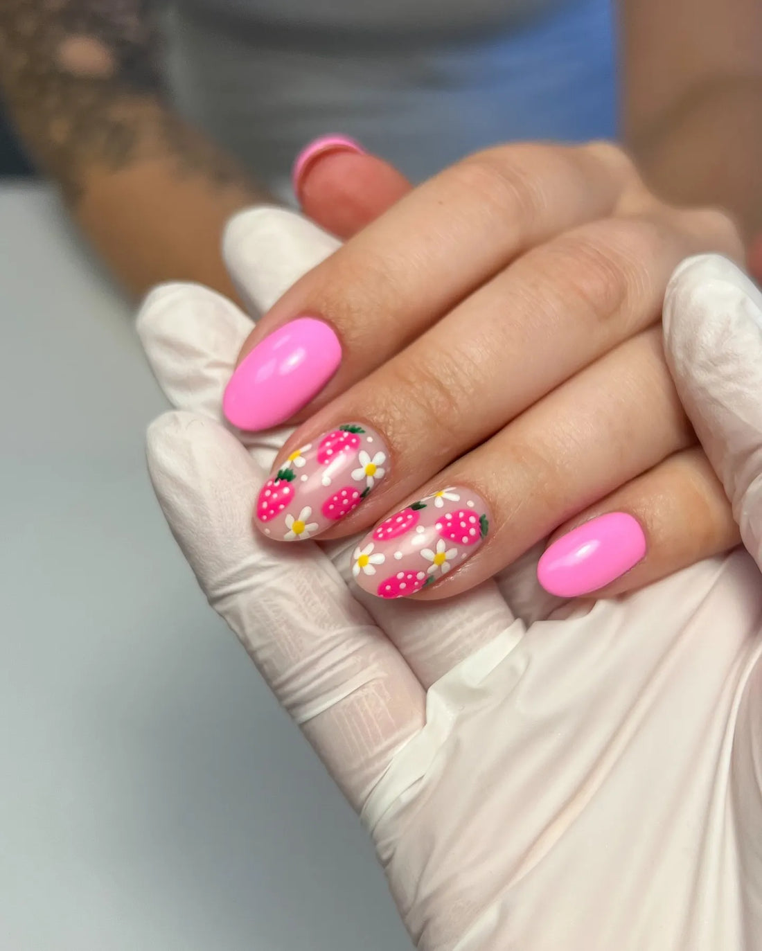 Handmade pink press-on nails with strawberry and daisy floral designs
