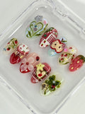 Handmade press-on nails with strawberry, apple, gingham, and floral 3D designs