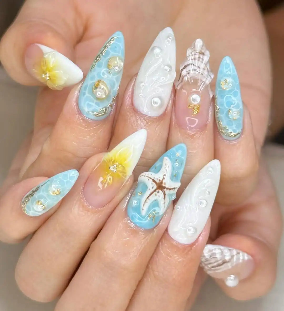 Handmade beach-themed press-on nails with starfish, seashell, pearl and ocean designs