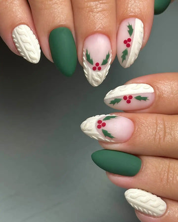 Handmade green press-on nails with white sweater texture and holly berry Christmas design.