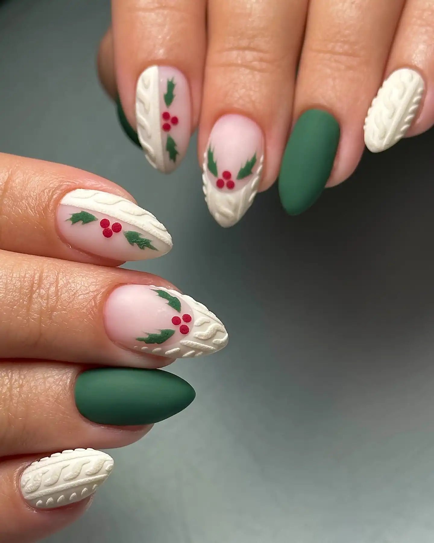 Handmade Christmas press-on nails with green matte, holly berry art, and sweater knit designs.