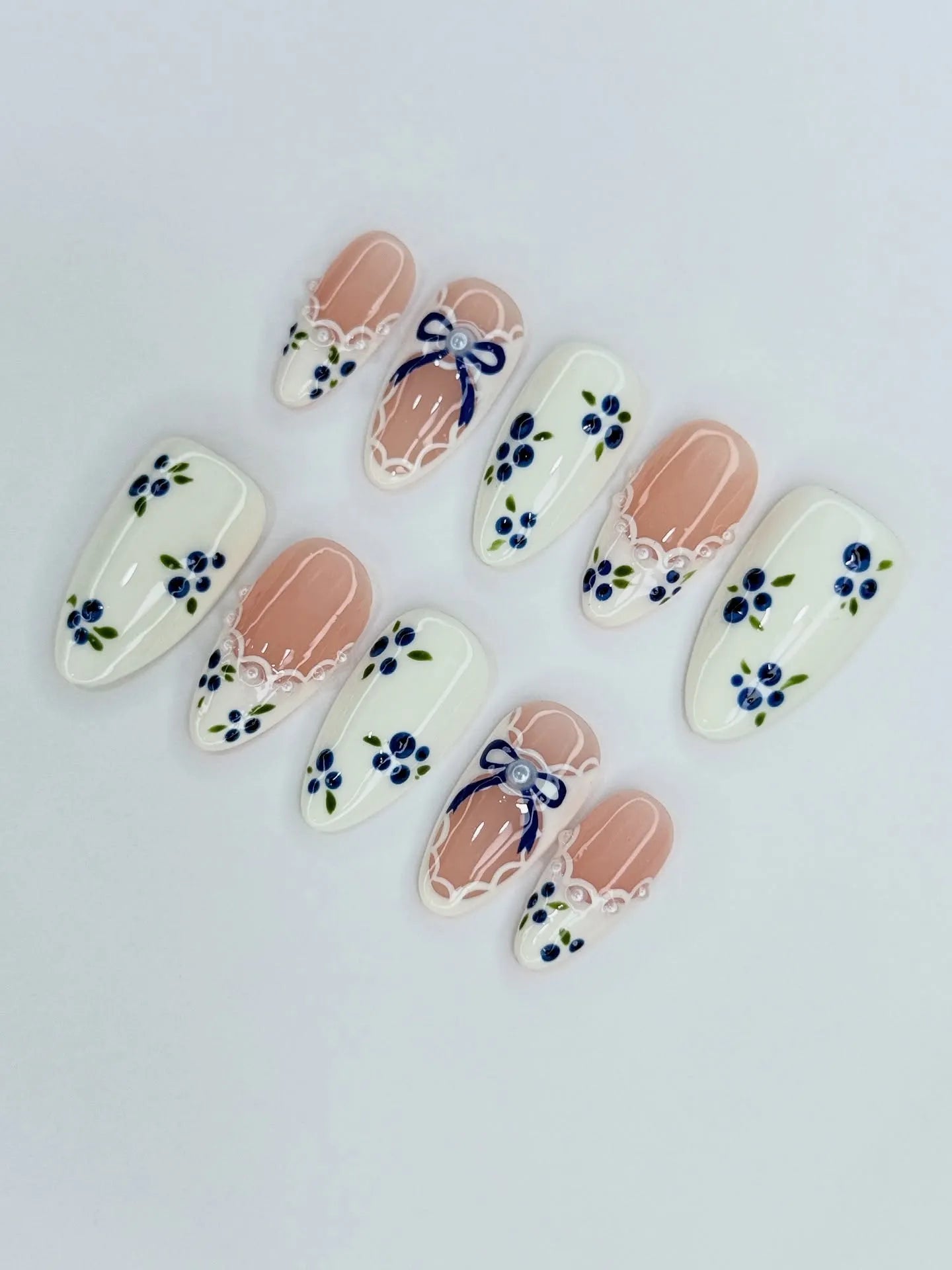 Handmade press-on nails with blue floral designs, lace ribbon, and picnic-inspired details.