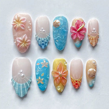 Handmade tropical flower and seashell press-on nails with beach vacation designs.