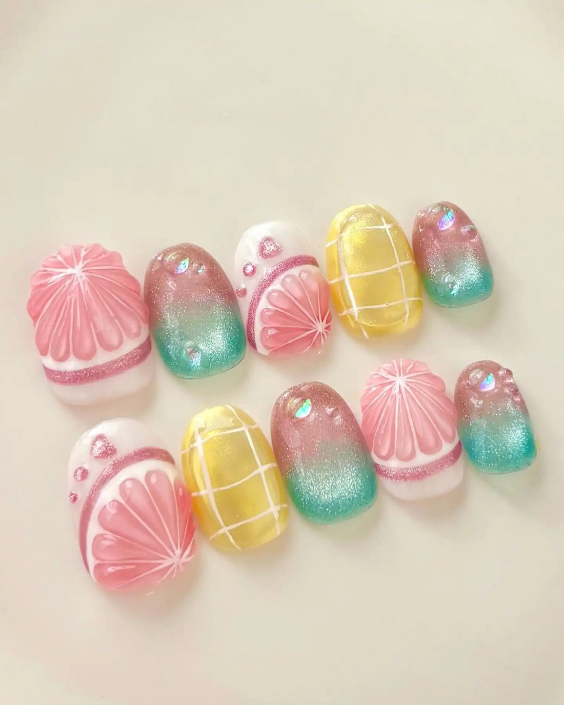 Handmade press-on nails with tropical fruit gradient, yellow grid, and shimmering summer design