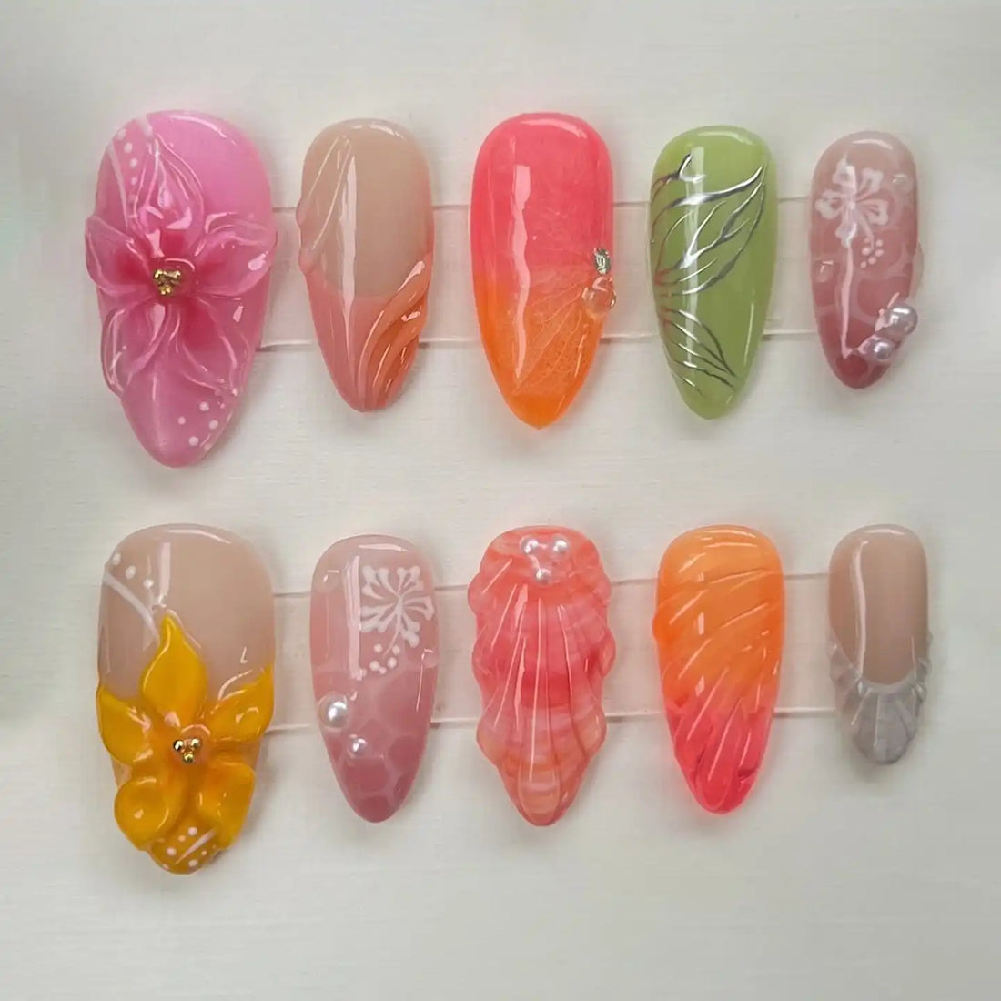 Handmade press-on nails with tropical orchid, leaf, shell, and sunset beach designs