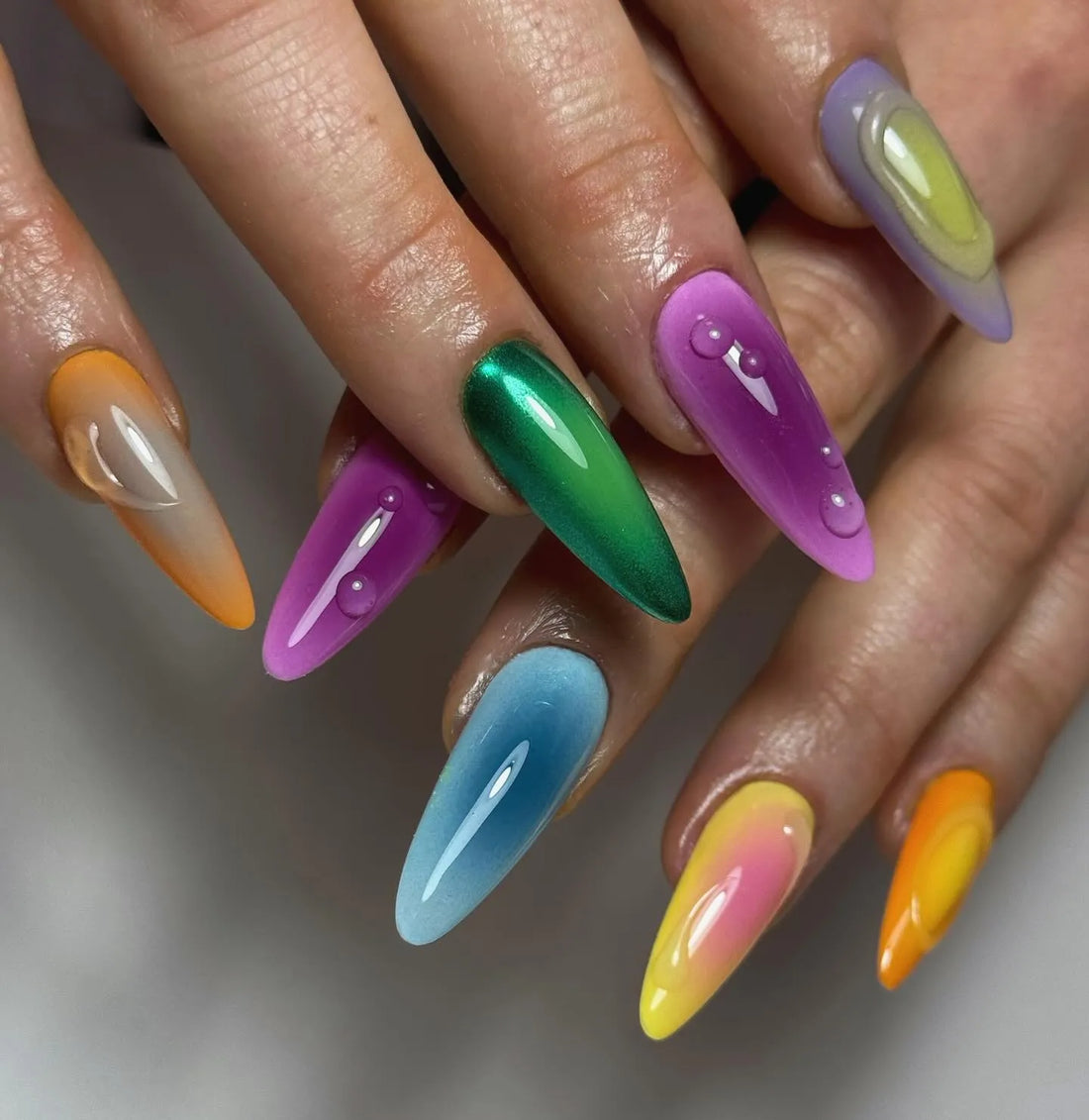 Handmade press-on nails with vibrant rainbow chrome and liquid drip design