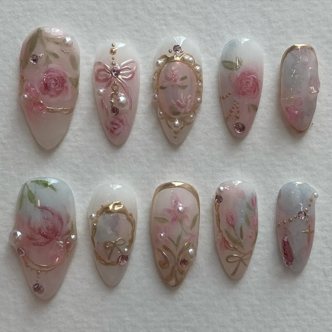 Handmade vintage press-on nails with pink rose, pearl, gold frame, and bow designs.