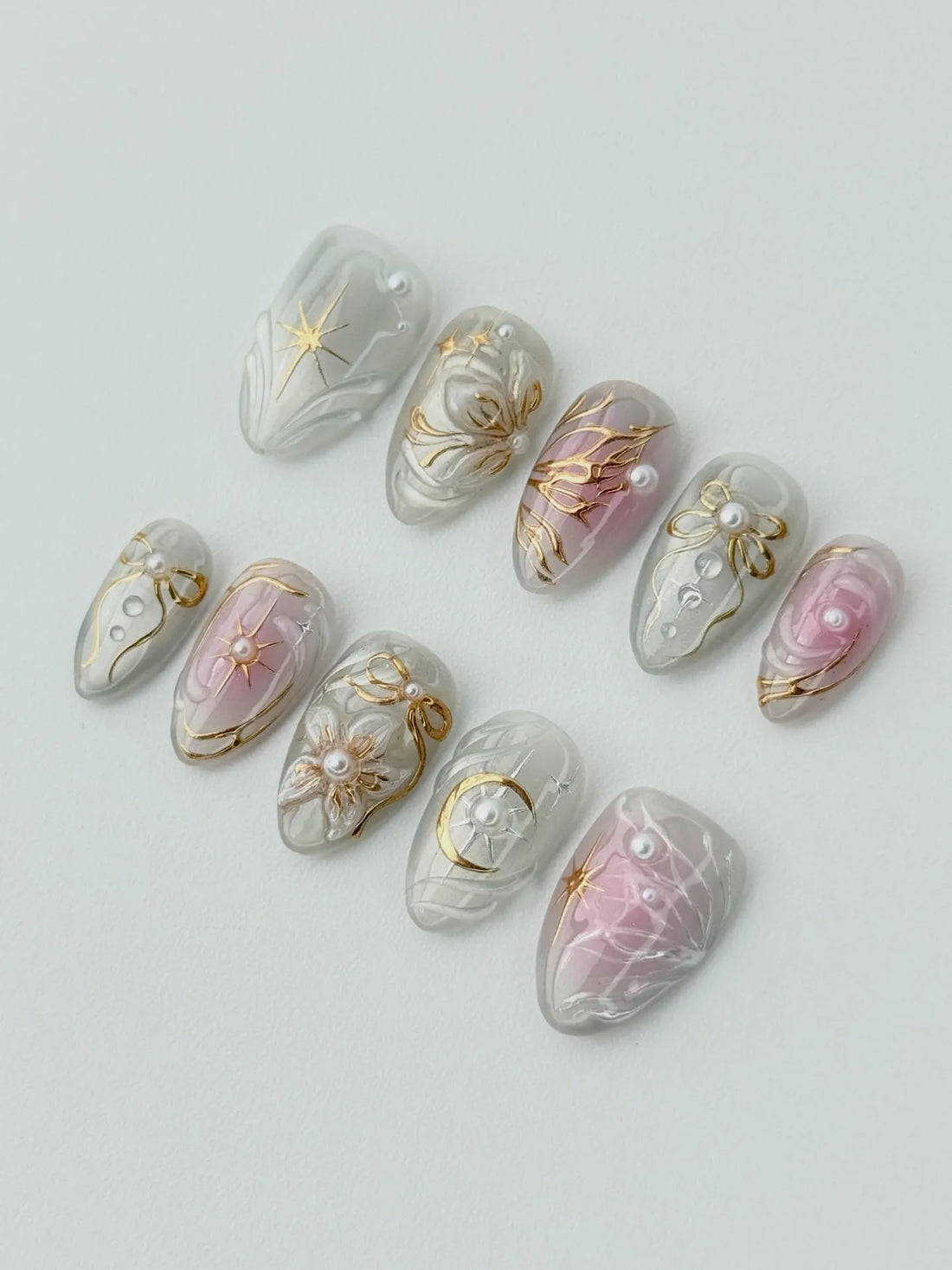 Handmade press-on nails with white, gold, and pearl celestial moon and star designs.