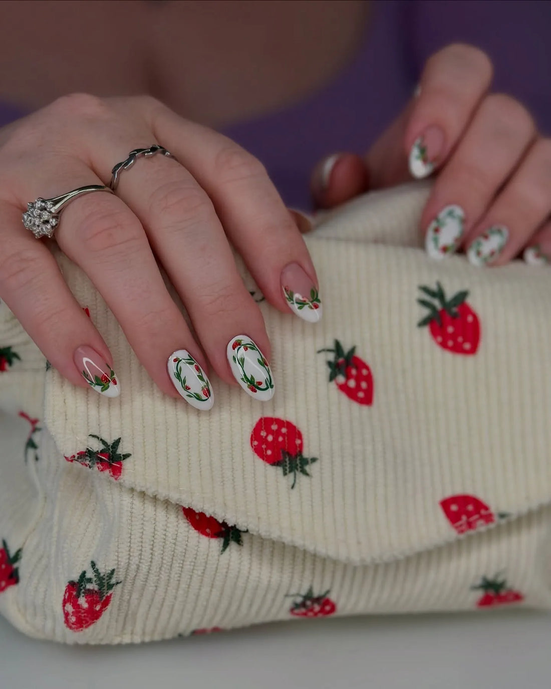 Handmade white and nude press-on nails with painted strawberry wreath nail art.