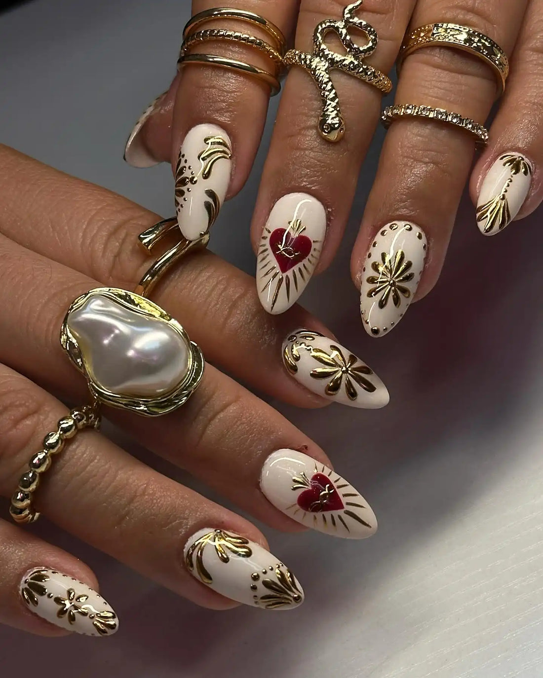 Handmade white press-on nails with gold floral accents and red heart design