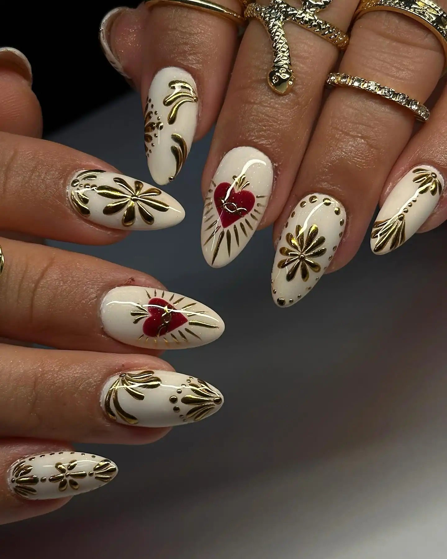 Handmade white press-on nails with gold floral and red heart sacred designs.