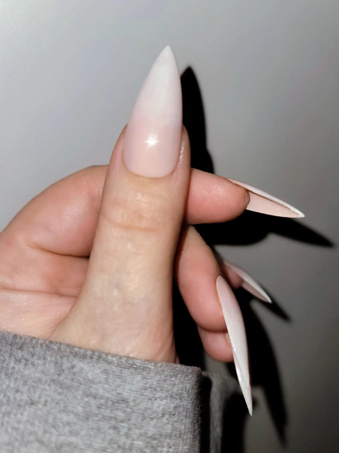 Hand with long stiletto pastel French tip handmade press-on nails