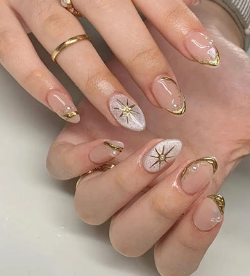 Shimmery pearl gold custom handmade press-on nails with star accents and metallic tips