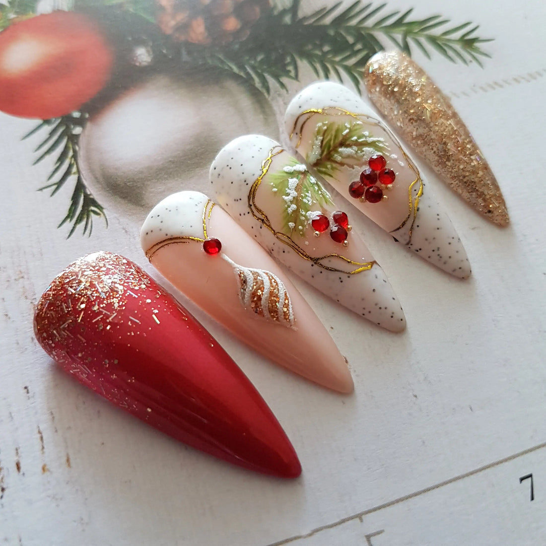 Christmas themed press-on nails with red, gold, glitter, and festive holiday designs