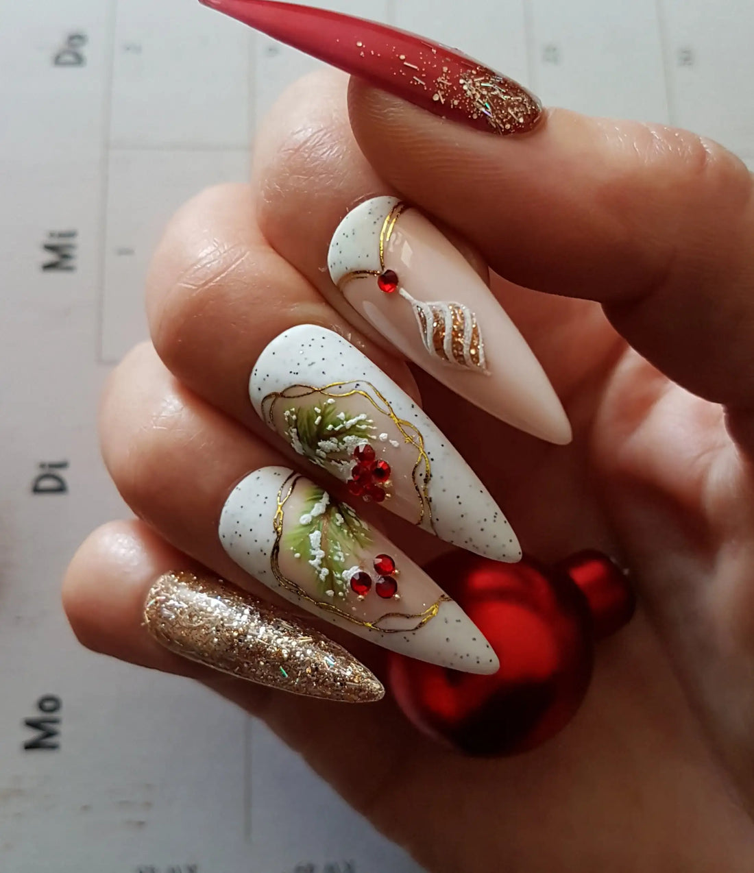 Christmas themed press-on nails with red, gold, glitter, and festive holiday designs