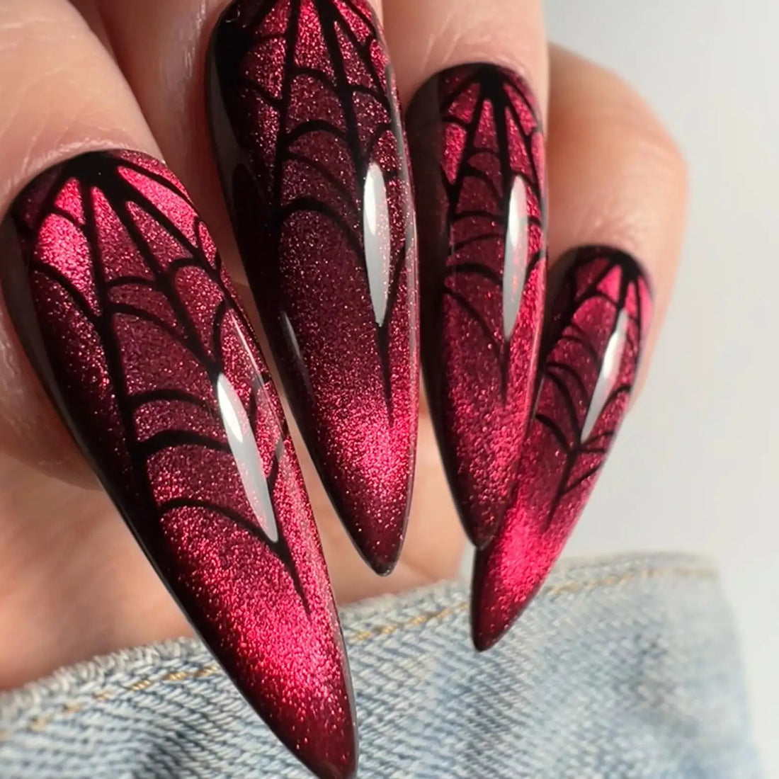 Red velvet cat eye press-on nails with black spider web Halloween nail art design