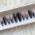 Handmade press-on nails with black ombre, glitter, moon and star designs in a box
