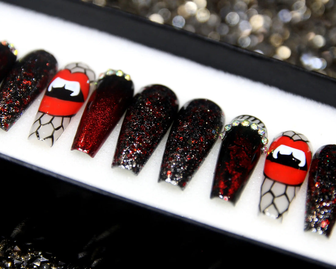 Halloween press-on nails with red glitter, vampire lips, and spider web designs displayed in a box