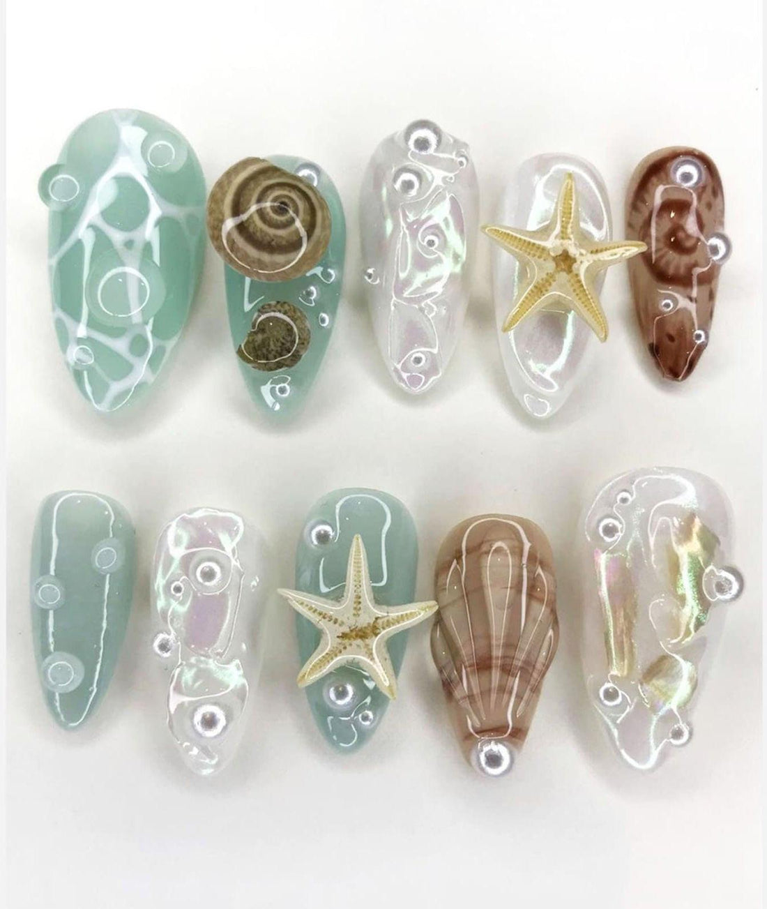 Handmade reusable press-on nails with sea shell, starfish, and ocean-inspired designs.