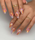 Hand with long almond-shaped iridescent press-on nails, gradient pastel design, gold rings